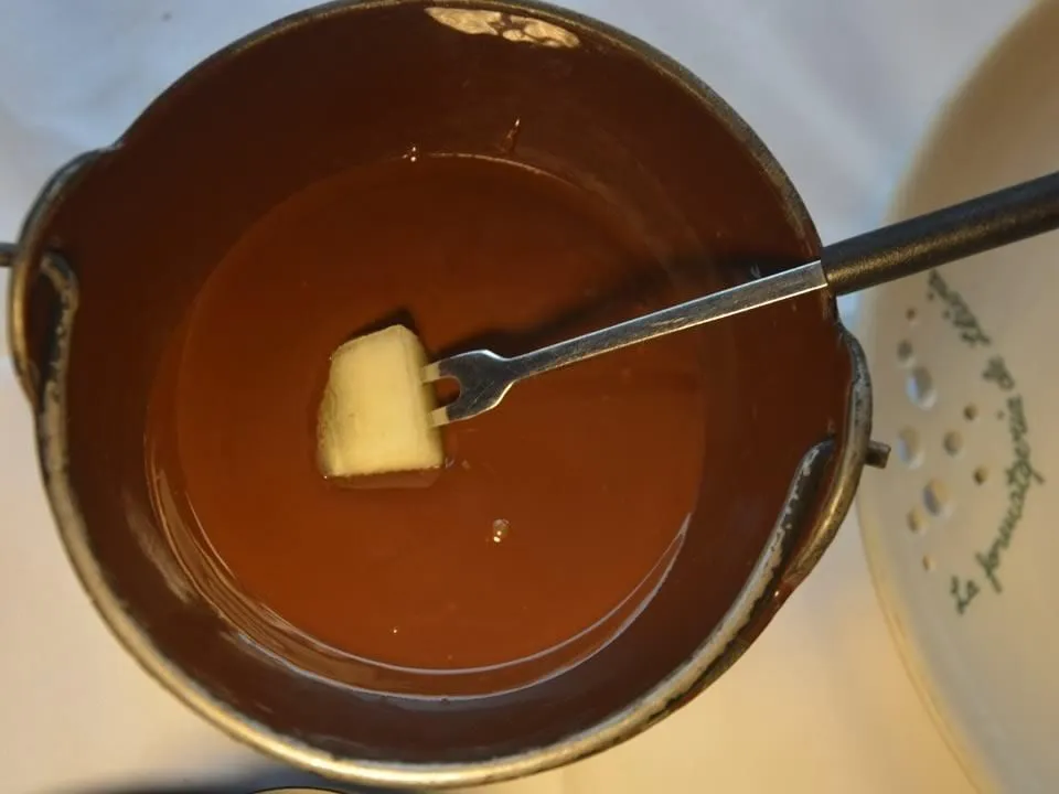 Fondue de xocolata de La Formatgeria de Llívia, amb un tall de fruita clavat a la forquilla